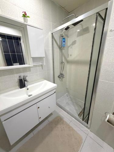 a white bathroom with a sink and a shower at King Suite SS7 in Istanbul