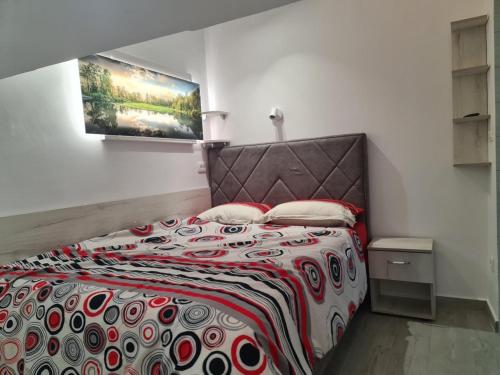a bedroom with a bed with a red and white blanket at Apartman Angela in Igalo