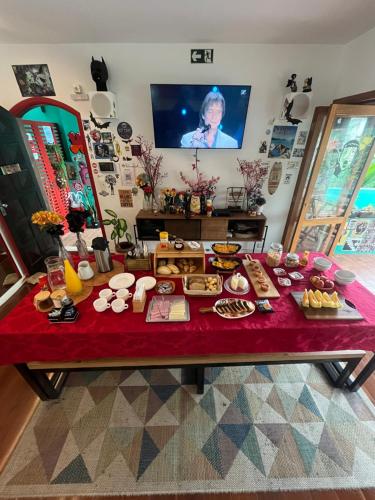 a table with a red table cloth with food on it at Pousada Bat N Breakfast No Beco do Batman in São Paulo