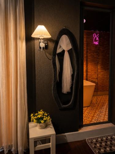 a bathroom with a mirror and a table with flowers at Spring Home 2 in Can Tho