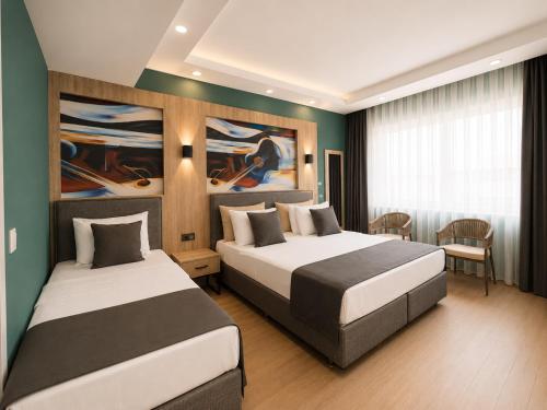 a hotel room with two beds and a table at Deniz Boutique Hotel in Antalya