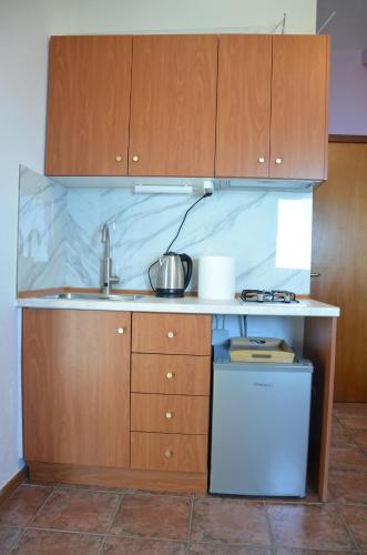 a kitchen with a sink and wooden cabinets at Sunray Room for Two in Zagora in Zagora