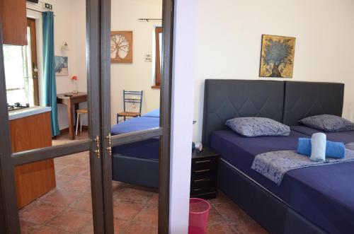 a bedroom with a bed with blue sheets and a mirror at Sunray Room for Two in Zagora in Zagora
