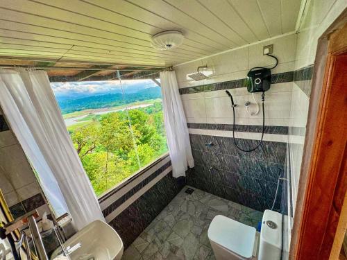 a bathroom with a shower and a sink and a window at Victoria Sky Crest - Kandy in Teldeniya