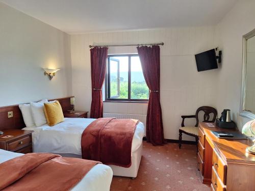 a hotel room with two beds and a window at Corthna Lodge in Schull