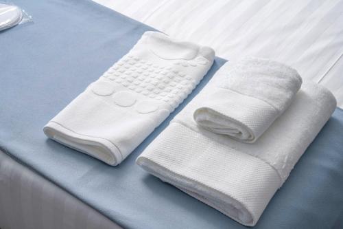 two white towels sitting on top of a bed at GRIG Villa & Hotel in Stepʼanavan
