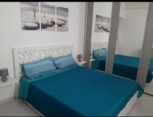 a bedroom with two beds and a mirror at Casa via maucini in Pachino