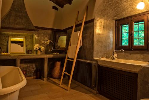 een badkamer met een wastafel, een toilet en een spiegel bij Αrnica Montana in Tsagarada