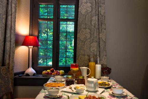 a table with food on it with a window and a table with food at Αrnica Montana in Tsagarada