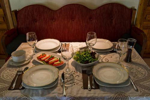 a table with plates of food and a bowl of fruit at Αrnica Montana in Tsagarada