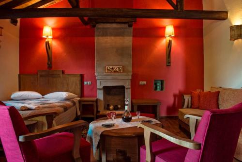 a red room with two beds and a fireplace at Αrnica Montana in Tsagarada