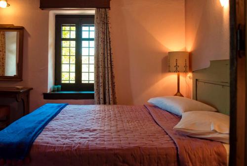 a bedroom with a bed and a window at Αrnica Montana in Tsagarada