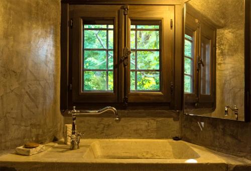 a bathroom with a large tub with a window at Αrnica Montana in Tsagarada
