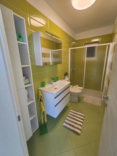 a bathroom with a sink and a shower and a toilet at Apartment Mia in Rab