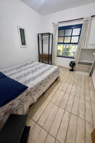 a bedroom with a bed and a large window at Casa em Ilha Comprida in Ilha Comprida
