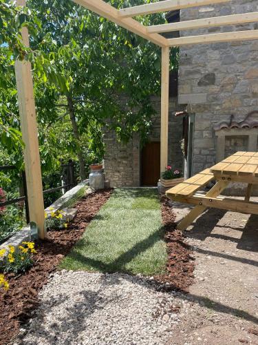 a wooden pergola and a picnic table in a yard at Quercus La Baita in La Verna
