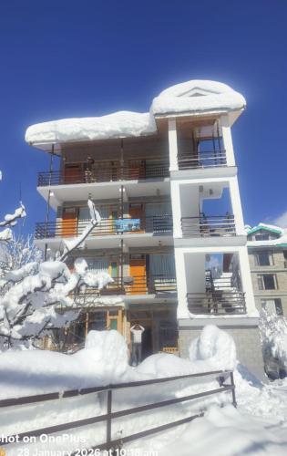 a building covered in snow with snowcovered trees in front at The Snow Rock in Palchān