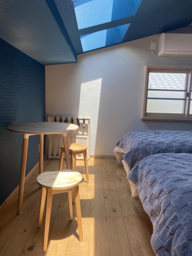 a room with a bed and a table and a bed and a bedskirts at 鍬と本 in Kagawa