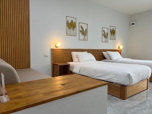 a hotel room with two beds and a table at Wilawan home in Ko Samui
