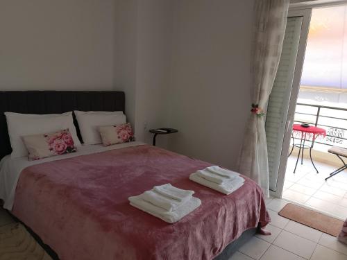 a bedroom with a bed with towels on it at Alkyona in Patra
