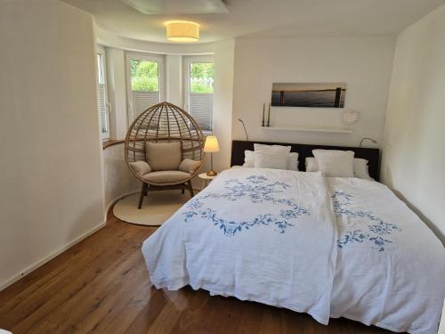 a bedroom with a large bed and a chair at Fewo Simone - Überlingen City - in Überlingen
