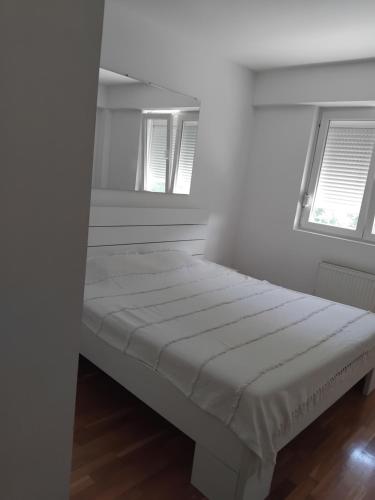 a white bed in a room with two windows at Zvezdica in Užice