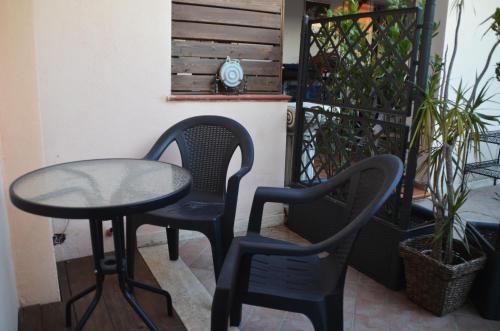 two chairs and a table on a balcony at For Ever Apartments in Fiumicino