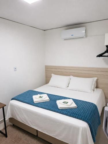 a bedroom with a bed with two towels on it at Hotel Pampa in Nova Santa Medianeira