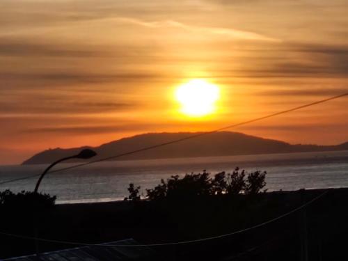 a sunset over the ocean with a mountain in the background at Terraza del atardecer in Vilar