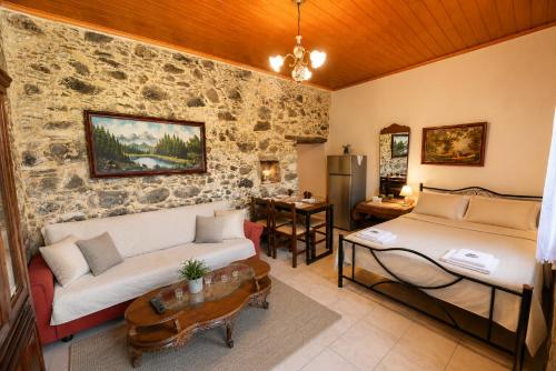 a living room with a couch and a bed at Pandora Stone Cottage Elos in Élos