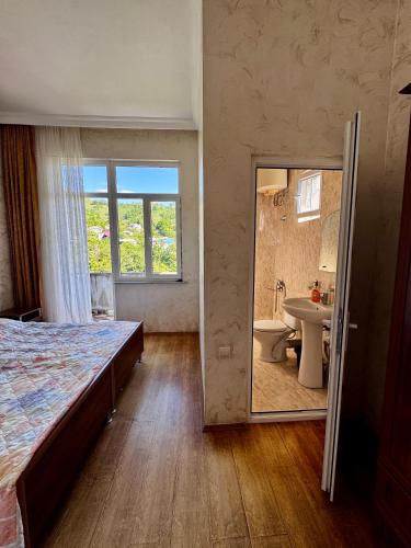 a bedroom with a bed and a sink and a mirror at Guest House in Sarpi in Batumi