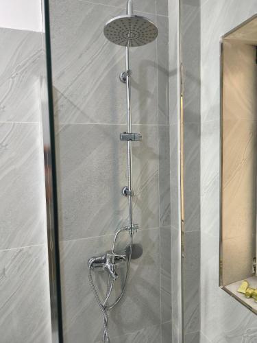a shower with a shower head in a bathroom at Melina Rooms in Dhërmi
