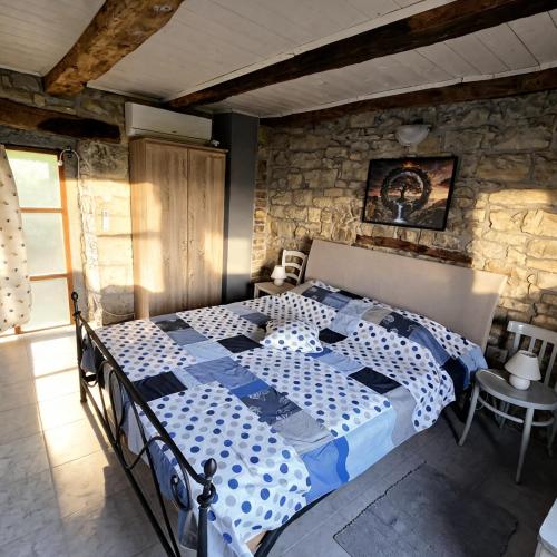 a bedroom with a bed in a stone wall at Kuća Zanetta sa bazenom in Buzet