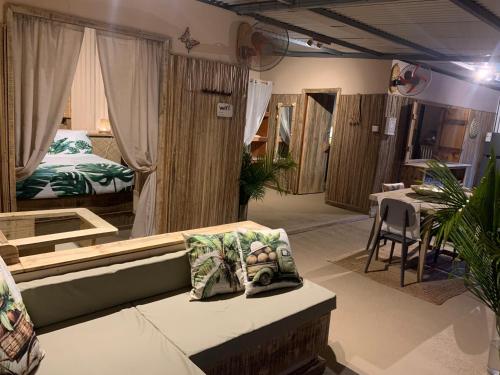 a room with a couch and a bed and tables at Sunrise Lodge Ocean View in Port Mathurin