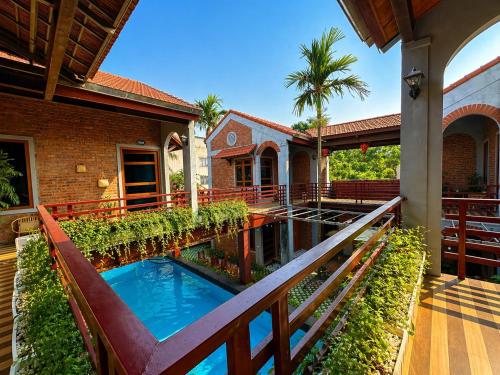 an external view of a house with a pond in the yard at Gecko Backpackers Hostel in Ninh Binh