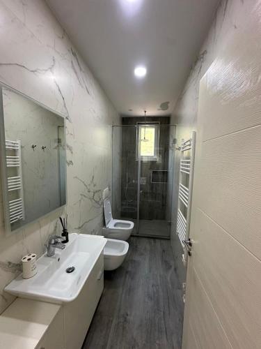 a bathroom with two sinks and a shower and a toilet at Vila Eva Lalz in Draç