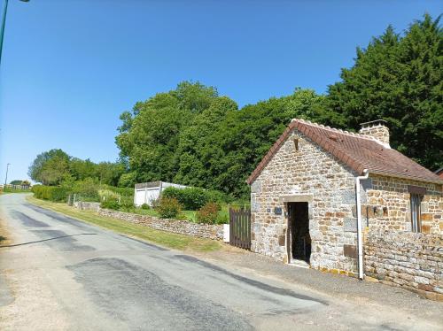 an old stone building on the side of a road at La Cahute, gîte étape in La Forêt-Auvray