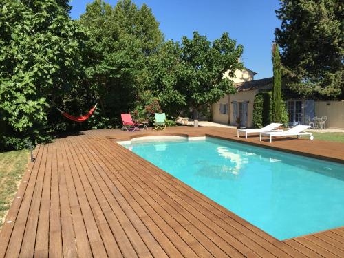 - une piscine sur une terrasse en bois à côté d'une maison dans l'établissement Mas Li Doumenge, à Orange