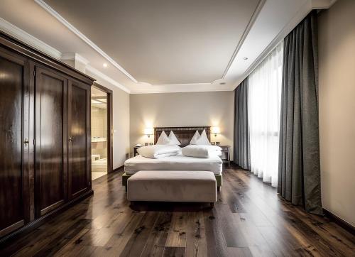 a hotel room with two beds and a large window at Hotel Luna Mondschein in Ortisei