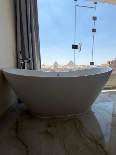 a white bath tub in a room with a window at Pyramids gardens guest House in ‘Ezbet `Abd el-Ḥamîd