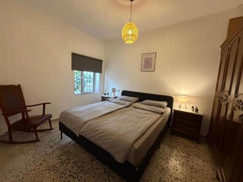 a bedroom with a bed and a chair and a lamp at Casa Hjort in Nerja