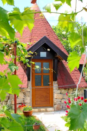 a small brick house with a wooden door at Seosko domaćinstvo Peković in Danilovgrad
