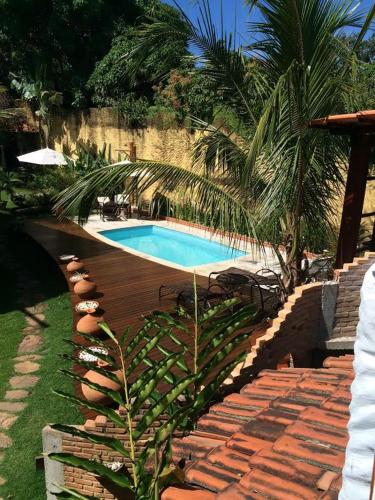 a swimming pool in a yard with a palm tree at Pousada Bambu Brasil in Sao Jorge