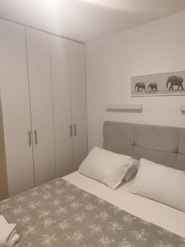 a bedroom with a bed and white cabinets at Apartman „Bernarda” in Korčula