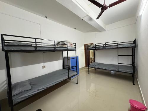 two bunk beds in a room with a ceiling at Mousumi Lodge in Tezpur