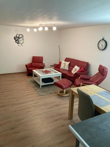 a living room with red furniture and a table at Peter's Ferienwohnung Nahe Rust, Kehl, Straßburg, Offenburg in Neuried