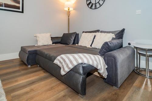 a couch and a chair in a living room at Gabriel's Gaff in Maidstone