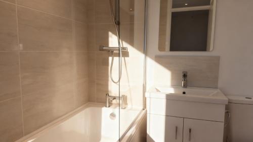 a white bathroom with a shower and a sink at Modern 2-Bed Apartment in Ramsgate in Ramsgate