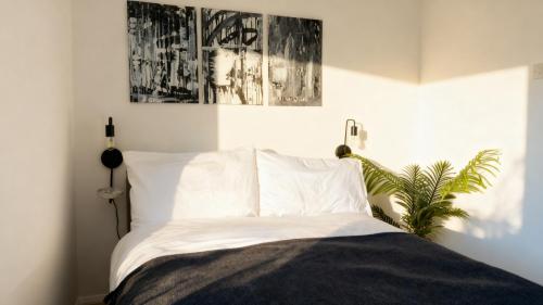 a bedroom with a bed with white sheets and a plant at Modern 2-Bed Apartment in Ramsgate in Ramsgate