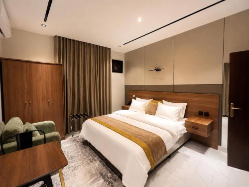 a hotel room with a large bed and a chair at كادي بارك الخليج in Riyadh